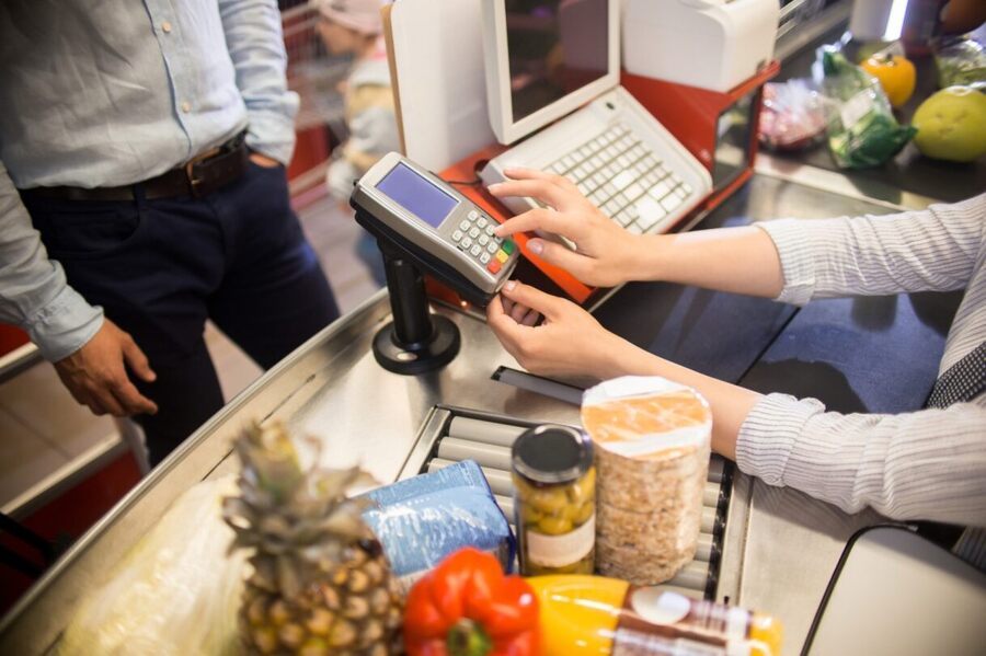 A cashier using a debit card pin pad.